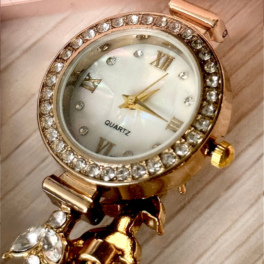 Gold crystal bezel quartz watch close-up on wooden surface