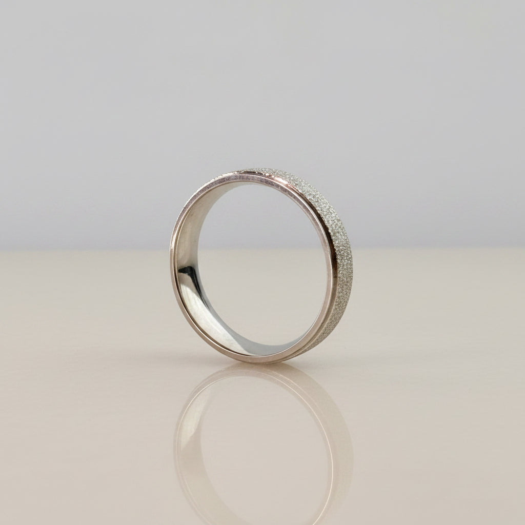 Silver stardust ring standing upright on marble surface