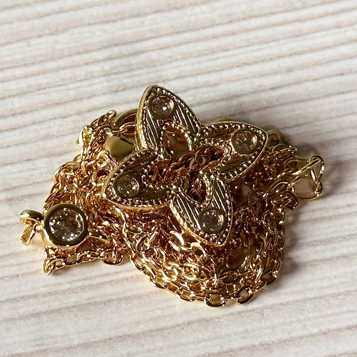 Gold filigree flower pendant close-up showing crystal and filigree detail